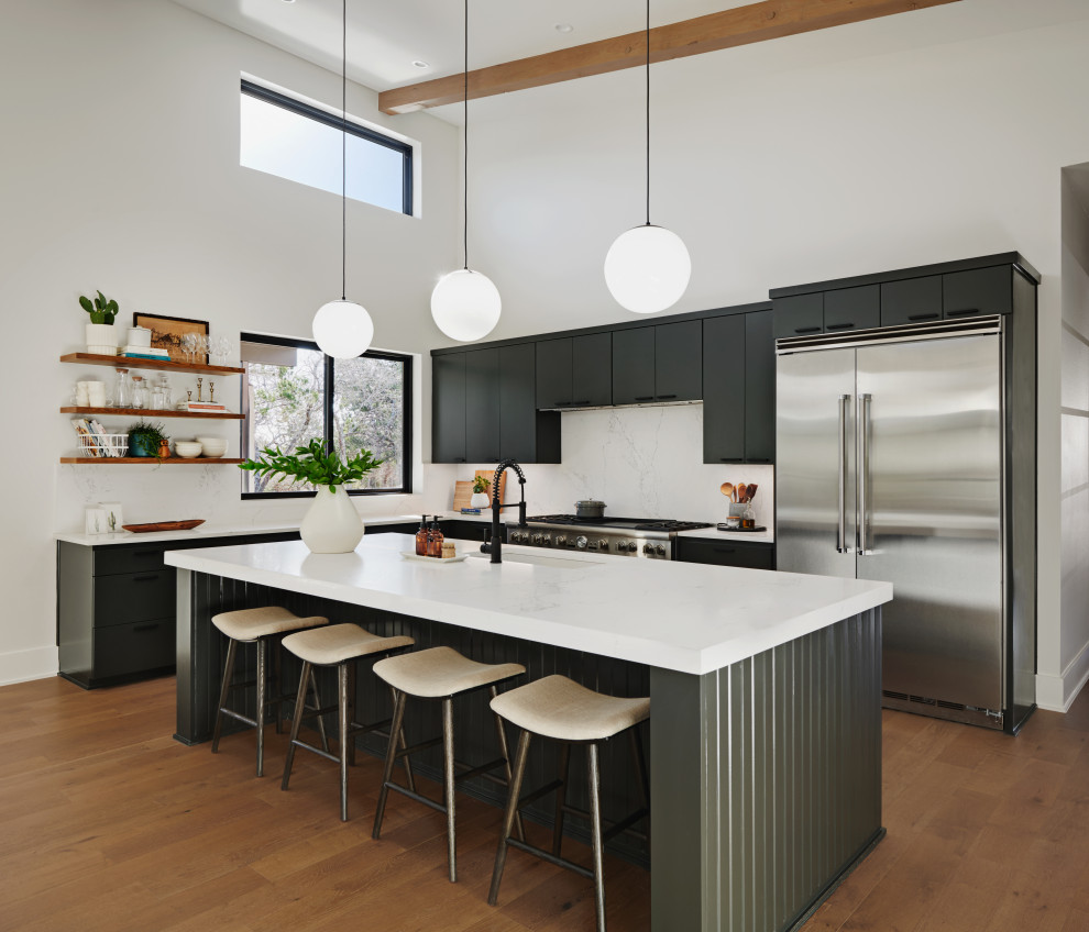 Foto di una cucina moderna con lavello sottopiano, ante lisce, ante nere, top in quarzite, paraspruzzi bianco, elettrodomestici in acciaio inossidabile, pavimento in legno massello medio e top bianco