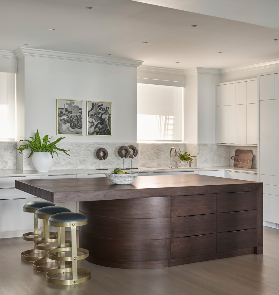 Example of a minimalist kitchen design in Chicago with flat-panel cabinets, paneled appliances and an island