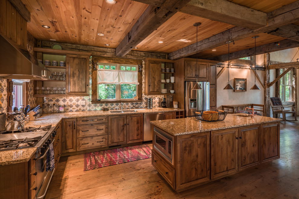 Kitchen - rustic l-shaped medium tone wood floor kitchen idea in Other with an undermount sink, raised-panel cabinets, medium tone wood cabinets, granite countertops, multicolored backsplash, ceramic backsplash, stainless steel appliances and an island