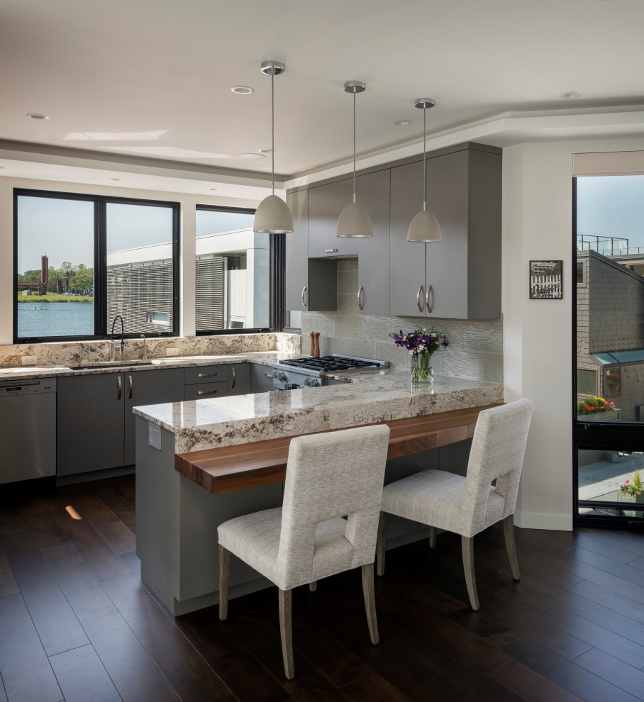 Exempel på ett modernt flerfärgad flerfärgat u-kök, med en undermonterad diskho, släta luckor, grå skåp, grått stänkskydd, rostfria vitvaror, mörkt trägolv, en halv köksö och brunt golv