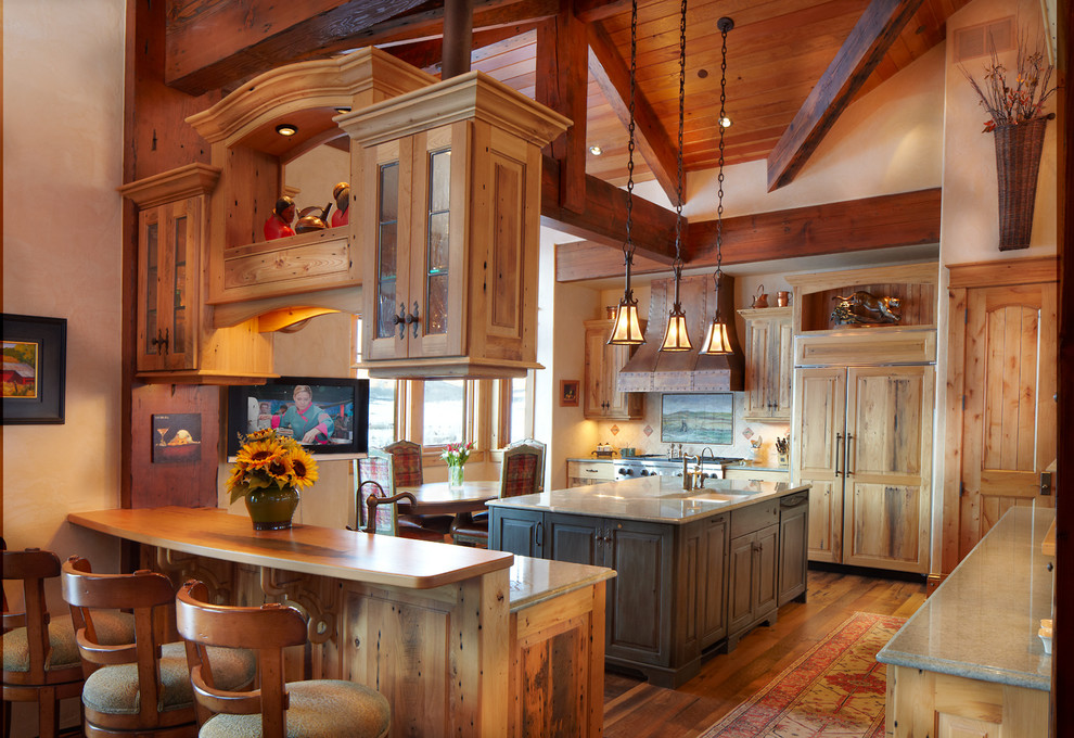 Exempel på ett stort rustikt grön grönt u-kök, med en undermonterad diskho, luckor med upphöjd panel, skåp i ljust trä, granitbänkskiva, flerfärgad stänkskydd, stänkskydd i travertin, integrerade vitvaror, mellanmörkt trägolv och flera köksöar