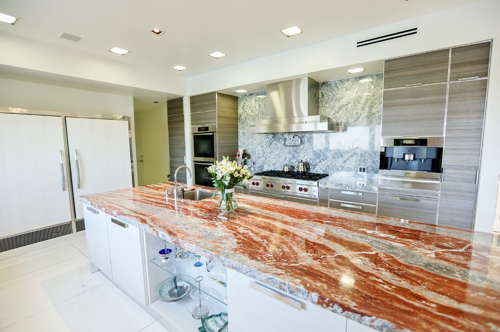 Design ideas for a large modern kitchen in Los Angeles with a submerged sink, flat-panel cabinets, grey cabinets, granite worktops, stone slab splashback, stainless steel appliances, marble flooring and an island.