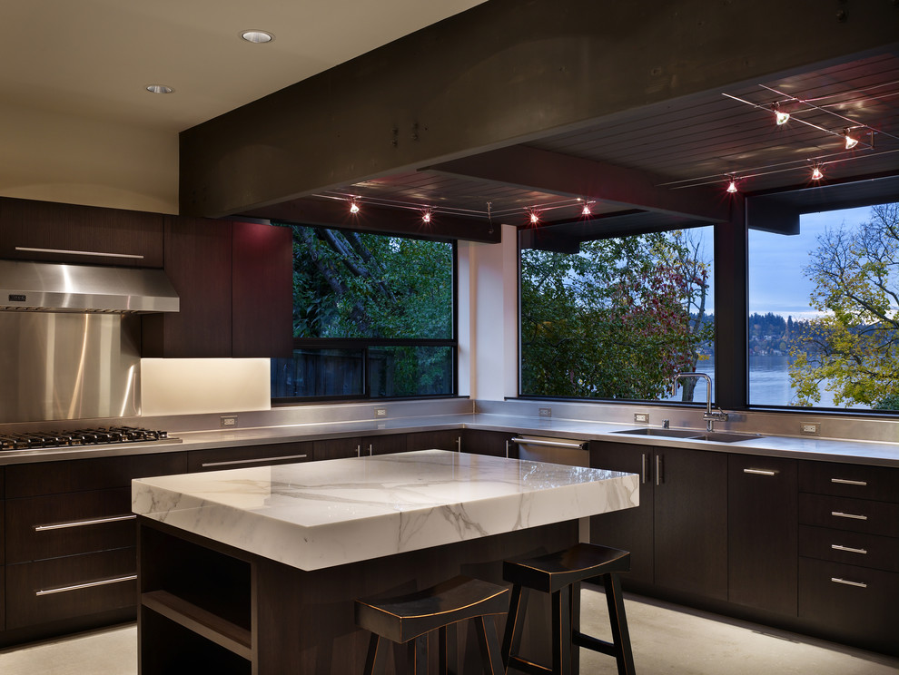 シアトルにあるモダンスタイルのおしゃれなキッチン (フラットパネル扉のキャビネット、濃色木目調キャビネット、シルバーの調理設備、大理石カウンター) の写真