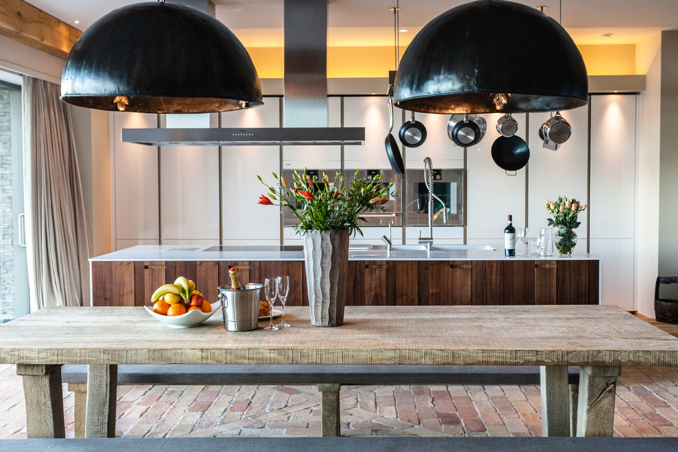 Foto di una cucina rustica con lavello integrato, ante lisce, ante bianche, elettrodomestici da incasso e pavimento in mattoni