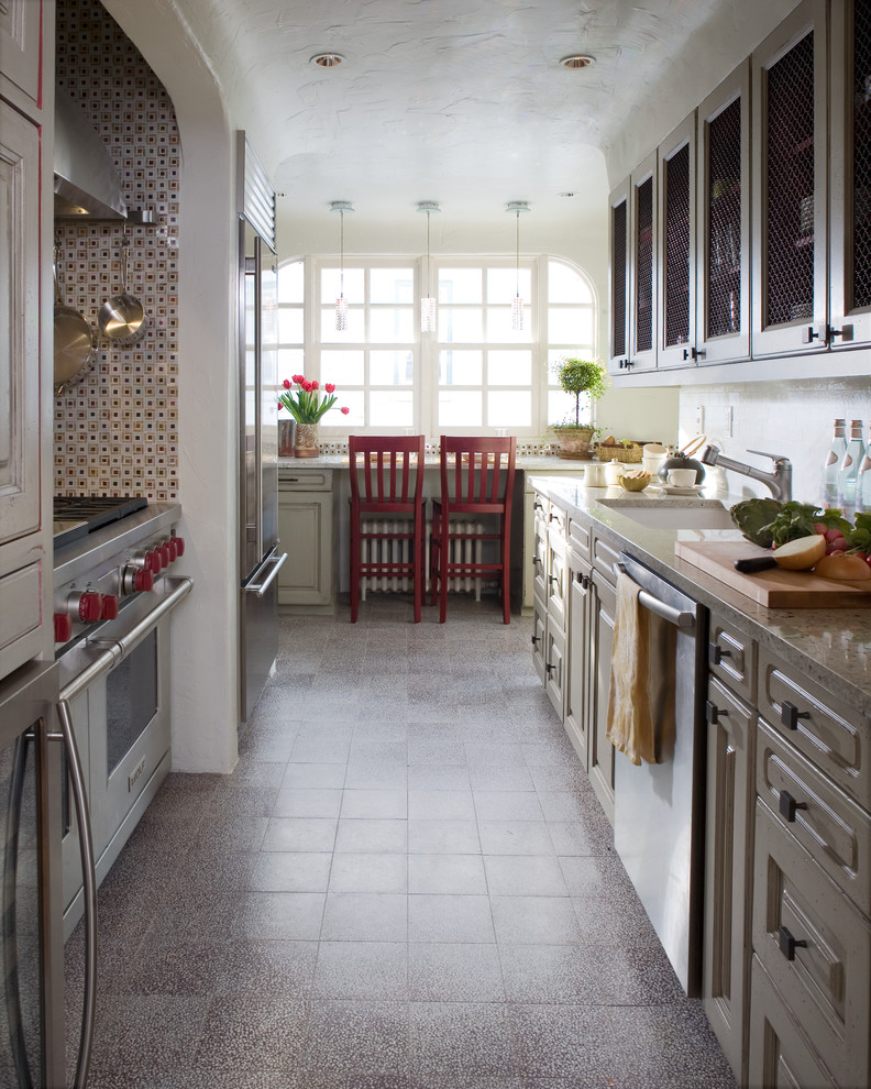 Cette image montre une cuisine américaine rustique avec un placard avec porte à panneau surélevé et un électroménager en acier inoxydable.