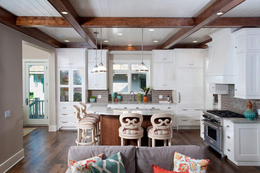 Inspiration for a coastal l-shaped dark wood floor open concept kitchen remodel in Grand Rapids with an undermount sink, shaker cabinets, white cabinets, gray backsplash, subway tile backsplash, stainless steel appliances and a peninsula