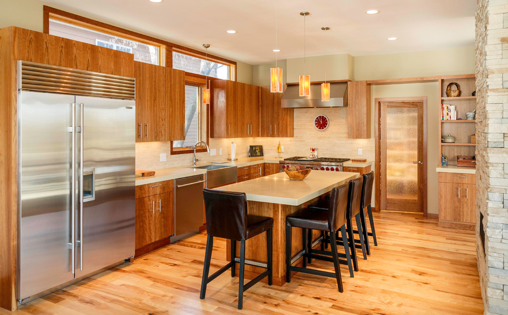 Large trendy l-shaped medium tone wood floor eat-in kitchen photo in Minneapolis with a farmhouse sink, flat-panel cabinets, medium tone wood cabinets, granite countertops, beige backsplash, porcelain backsplash, stainless steel appliances and an island