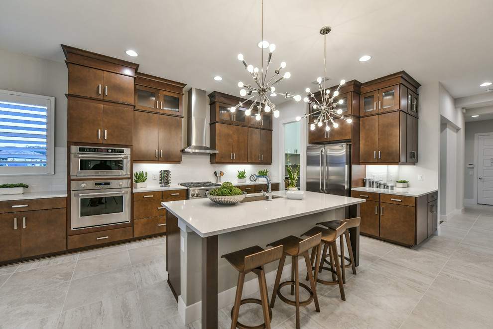 Inspiration for a large modern l-shaped open concept kitchen remodel in Other with a single-bowl sink, flat-panel cabinets, medium tone wood cabinets, white backsplash, subway tile backsplash, stainless steel appliances and an island