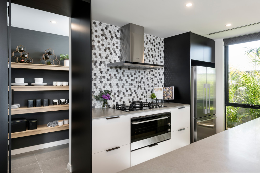 Idéer för att renovera ett mellanstort funkis grå grått kök, med en undermonterad diskho, släta luckor, svarta skåp, bänkskiva i betong, stänkskydd med metallisk yta, stänkskydd i mosaik, svarta vitvaror, klinkergolv i porslin, en köksö och grått golv