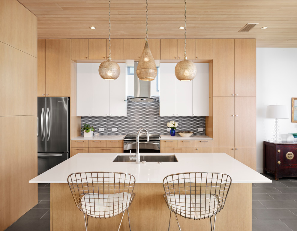 Idee per un cucina con isola centrale design con lavello sottopiano, ante lisce, ante in legno chiaro e elettrodomestici in acciaio inossidabile