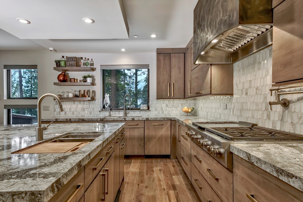 This is an example of a rustic l-shaped kitchen in Other with a submerged sink, flat-panel cabinets, medium wood cabinets, white splashback, stainless steel appliances, medium hardwood flooring, an island, brown floors and grey worktops.