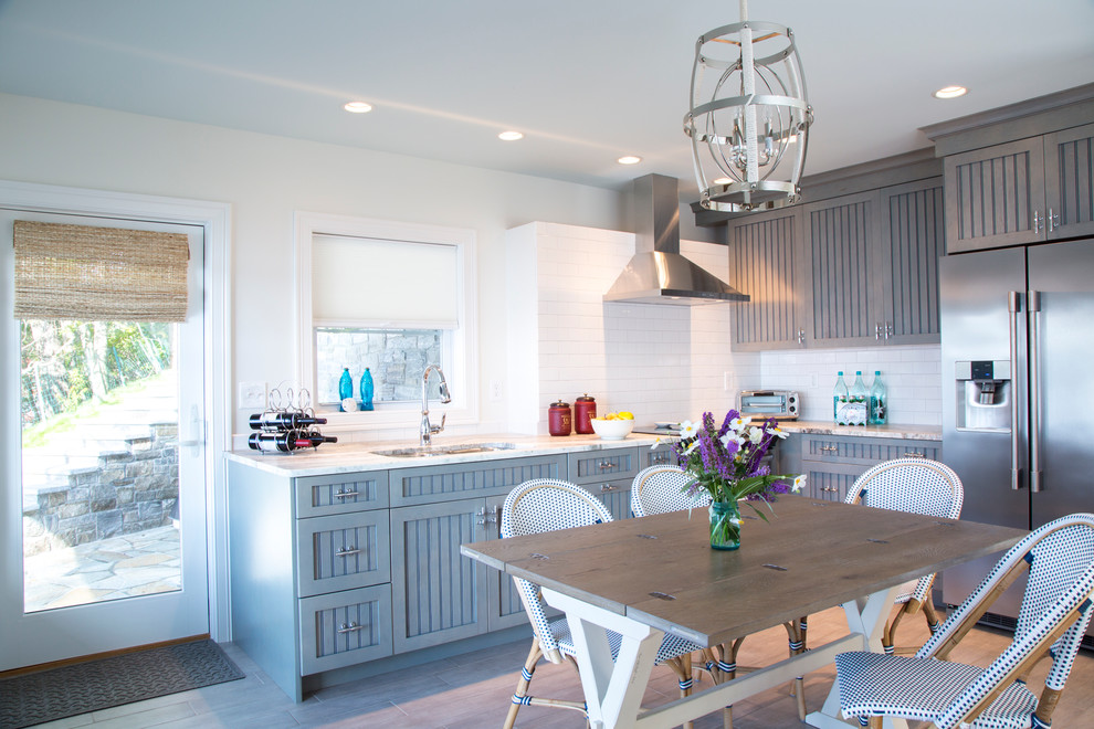 Eat-in kitchen - small coastal l-shaped porcelain tile eat-in kitchen idea in Bridgeport with a double-bowl sink, beaded inset cabinets, blue cabinets, quartzite countertops, white backsplash, subway tile backsplash, stainless steel appliances and no island
