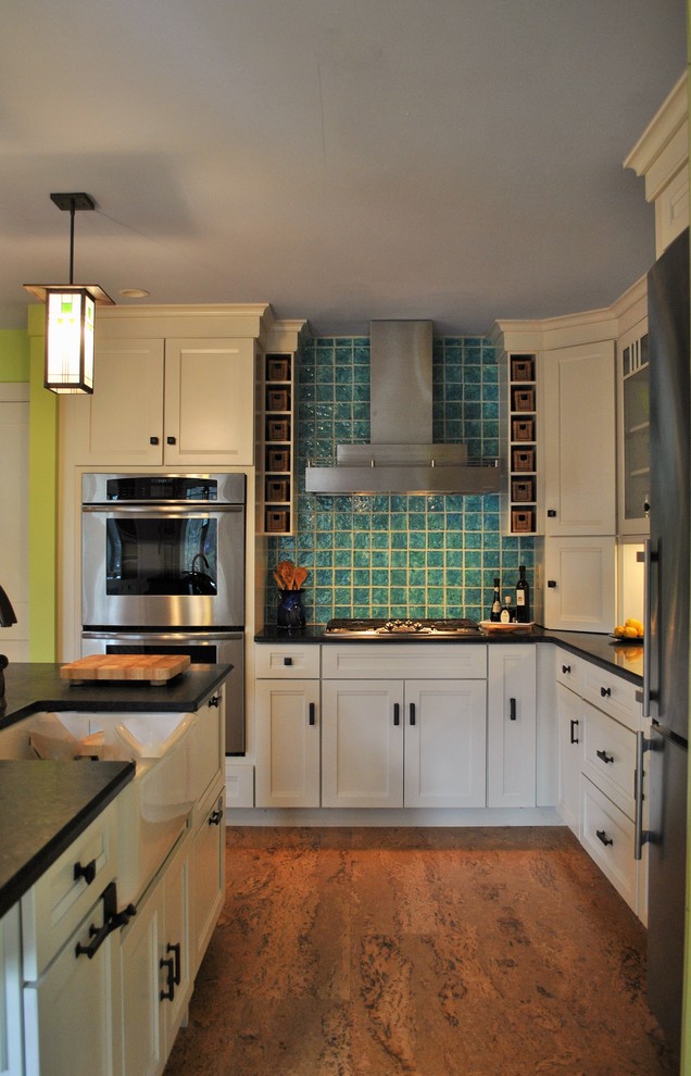 Klassisk inredning av ett stort kök med öppen planlösning, med en rustik diskho, skåp i shakerstil, vita skåp, granitbänkskiva, blått stänkskydd, stänkskydd i keramik, rostfria vitvaror, korkgolv, flera köksöar och brunt golv