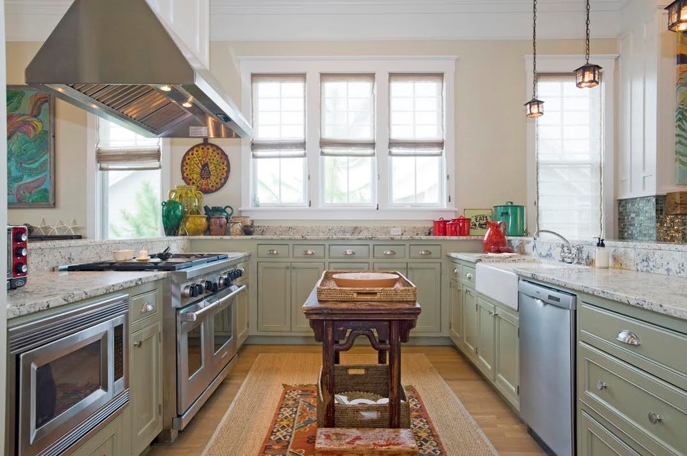 Bild på ett lantligt u-kök, med en rustik diskho, skåp i shakerstil, gröna skåp, rostfria vitvaror, mellanmörkt trägolv, en köksö och brunt golv
