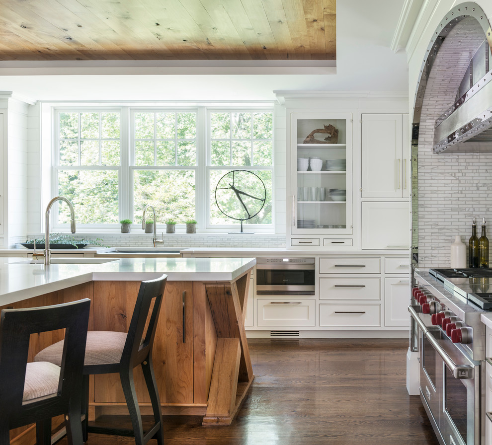 Klassische Küche mit Unterbauwaschbecken, Glasfronten, weißen Schränken, Küchenrückwand in Weiß, Küchengeräten aus Edelstahl, dunklem Holzboden und Kücheninsel in New York