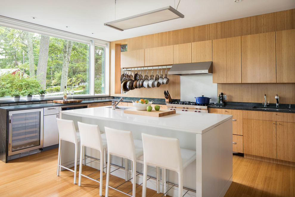 Design ideas for a contemporary l-shaped kitchen in Boston with a submerged sink, flat-panel cabinets, medium wood cabinets, brown splashback, stainless steel appliances, medium hardwood flooring, an island, brown floors and black worktops.