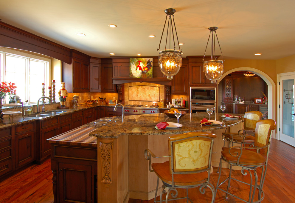 This is an example of a large traditional l-shaped enclosed kitchen in Cincinnati with a double-bowl sink, raised-panel cabinets, dark wood cabinets, granite worktops, beige splashback, cement tile splashback, stainless steel appliances, dark hardwood flooring and an island.