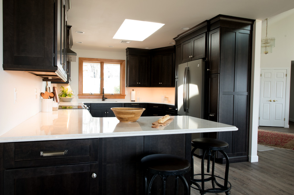Idéer för att renovera ett mellanstort funkis vit vitt kök, med en undermonterad diskho, skåp i shakerstil, skåp i mörkt trä, bänkskiva i kvarts, rostfria vitvaror, mellanmörkt trägolv, en halv köksö och grått golv