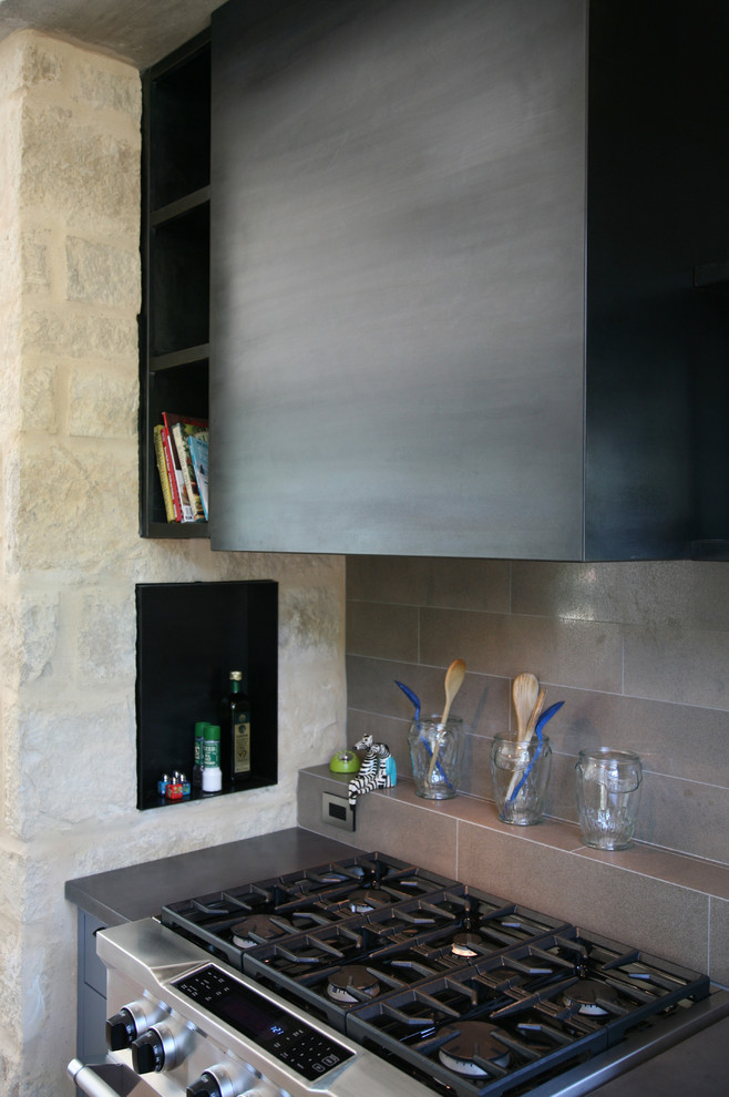 Example of a small minimalist l-shaped eat-in kitchen design in Austin with flat-panel cabinets, blue cabinets, concrete countertops, gray backsplash, porcelain backsplash, stainless steel appliances and an island
