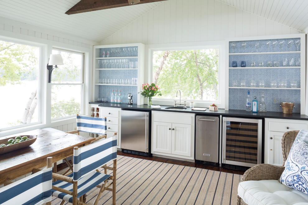 Inspiration for a medium sized nautical single-wall kitchen/diner in Portland Maine with recessed-panel cabinets, white cabinets, blue splashback, mosaic tiled splashback, dark hardwood flooring, no island, brown floors, black worktops, a submerged sink, engineered stone countertops and stainless steel appliances.
