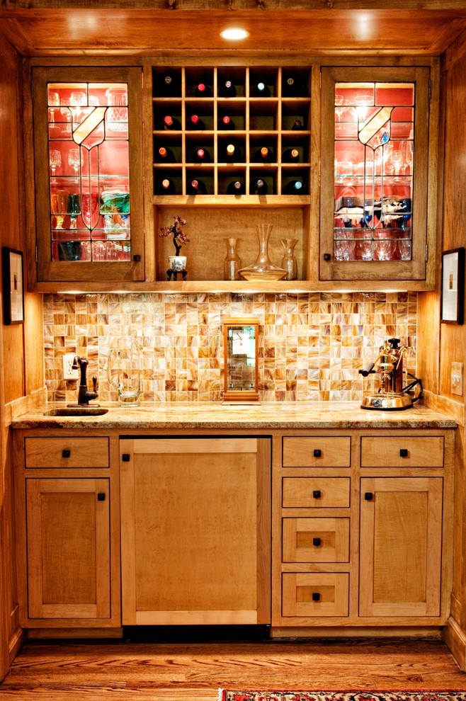 Diseño de bar en casa de galera tradicional pequeño con fregadero bajoencimera, armarios estilo shaker, puertas de armario de madera clara, encimera de granito, salpicadero marrón, salpicadero de azulejos de vidrio y suelo de madera en tonos medios