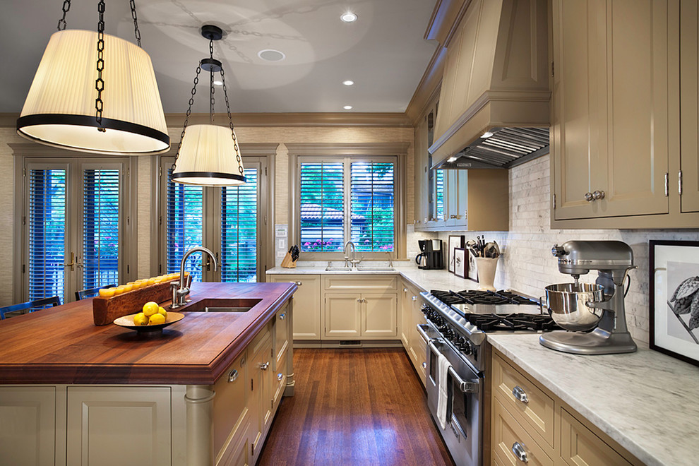 На фото: кухня в классическом стиле с техникой из нержавеющей стали и деревянной столешницей