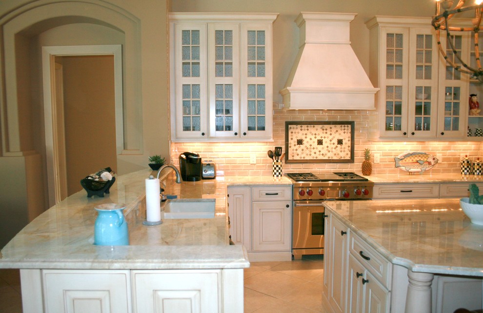 Immagine di una grande cucina chic con lavello sottopiano, ante con bugna sagomata, ante bianche, top in quarzite, paraspruzzi con piastrelle di vetro e elettrodomestici in acciaio inossidabile