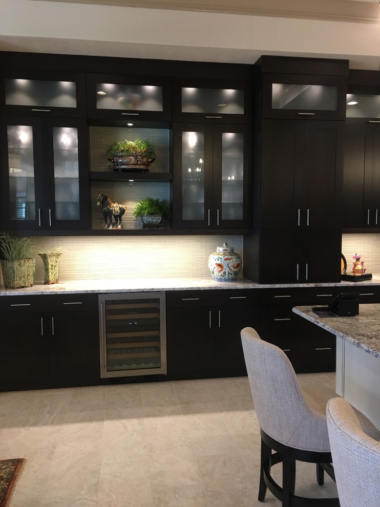 Photo of an expansive traditional l-shaped open plan kitchen in Tampa with a submerged sink, flat-panel cabinets, black cabinets, quartz worktops, white splashback, glass tiled splashback, stainless steel appliances, travertine flooring, multiple islands, grey floors and grey worktops.