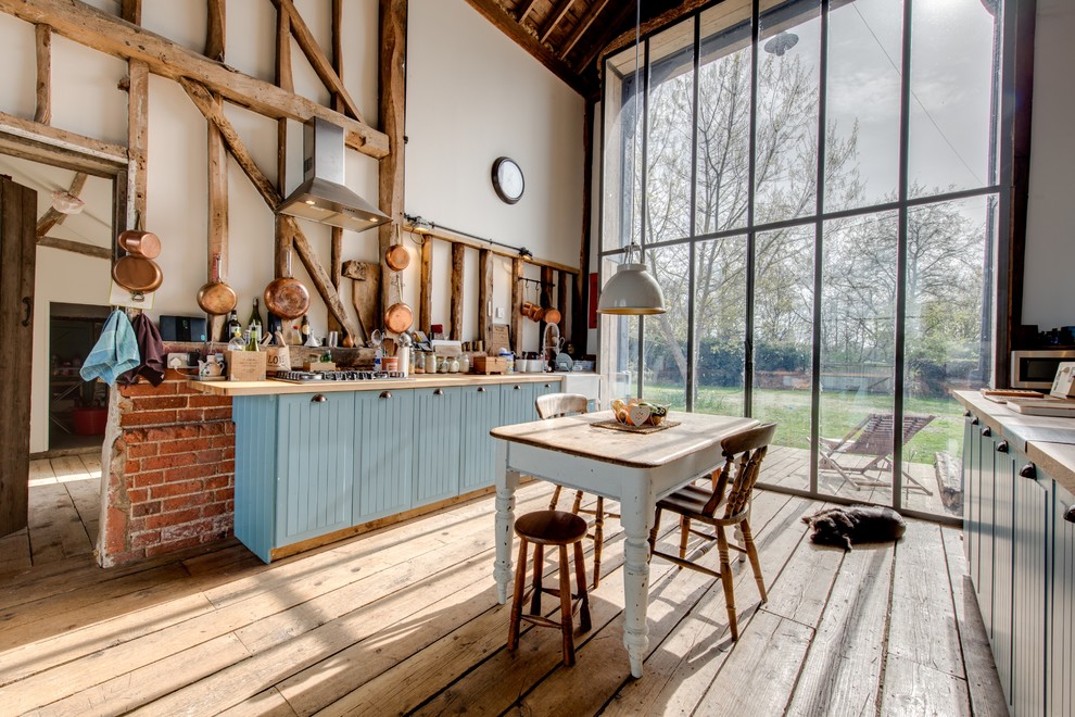 Inspiration for an expansive farmhouse single-wall kitchen in Other with blue cabinets, light hardwood flooring and no island.