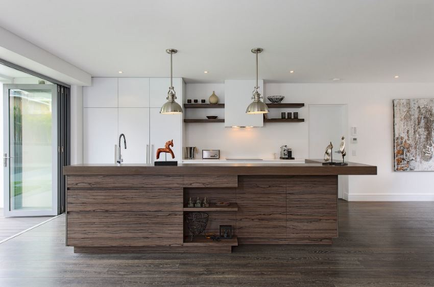 Diseño de cocina comedor lineal minimalista grande con armarios con paneles lisos, puertas de armario blancas, encimera de madera, electrodomésticos con paneles, suelo laminado y una isla