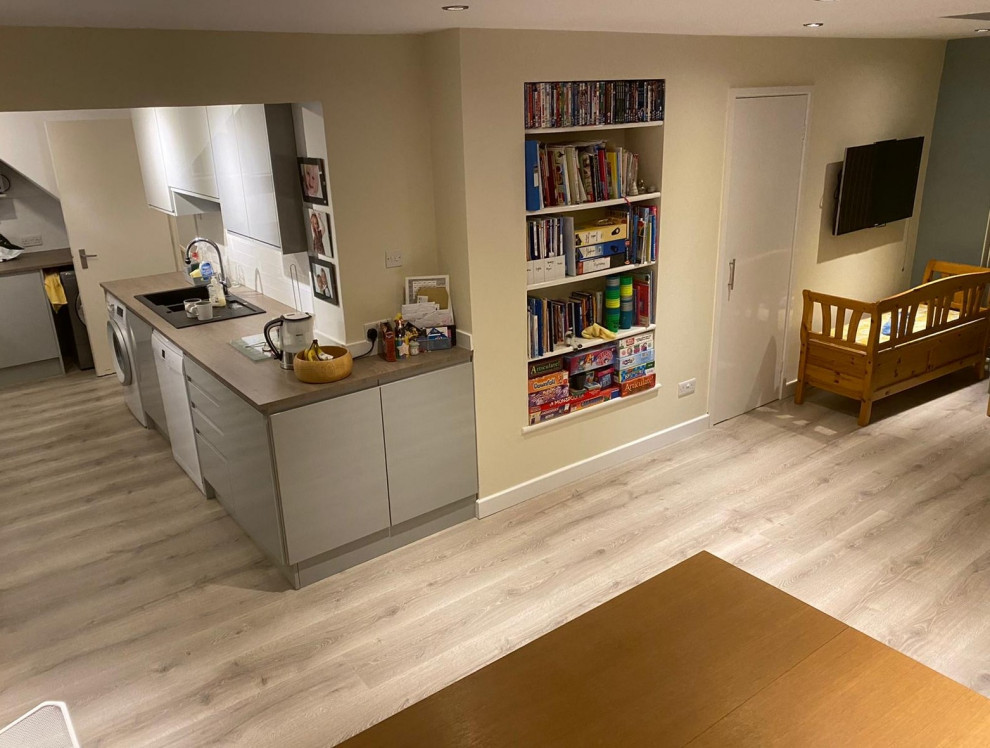 Immagine di una grande cucina a L moderna con lavello da incasso, pavimento in laminato, pavimento grigio e top marrone
