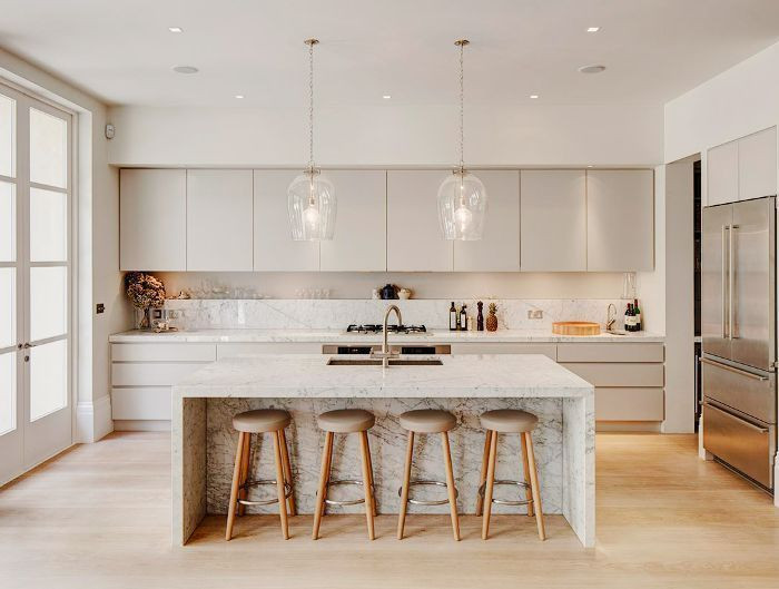 Example of a large trendy l-shaped light wood floor and brown floor eat-in kitchen design in Columbus with a drop-in sink, flat-panel cabinets, gray cabinets, quartz countertops, black backsplash, stone slab backsplash, stainless steel appliances, an island and white countertops