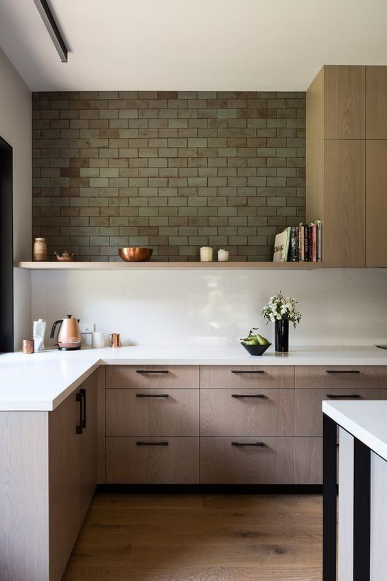 Bild på ett mellanstort funkis vit vitt kök, med en undermonterad diskho, släta luckor, bruna skåp, bänkskiva i kvarts, vitt stänkskydd, stänkskydd i sten, svarta vitvaror, ljust trägolv, en köksö och brunt golv