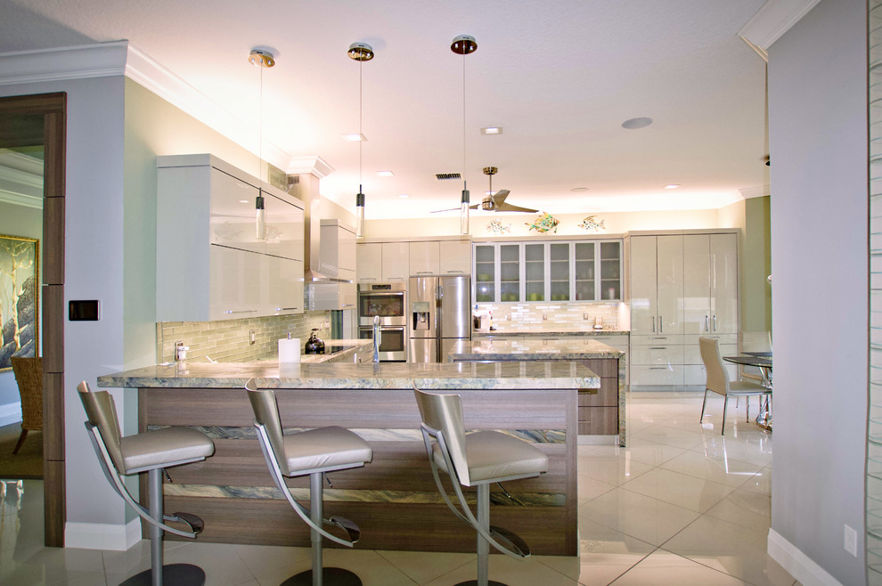 Example of a large trendy u-shaped marble floor and white floor open concept kitchen design in Miami with a farmhouse sink, flat-panel cabinets, green cabinets, granite countertops, green backsplash, glass tile backsplash, stainless steel appliances, an island and green countertops