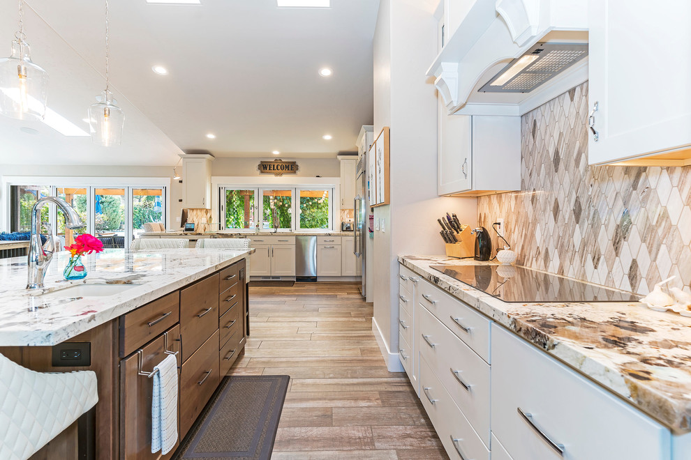 Country l-shaped medium tone wood floor and brown floor kitchen photo in Other with an undermount sink, flat-panel cabinets, white cabinets, beige backsplash, stainless steel appliances, an island and beige countertops