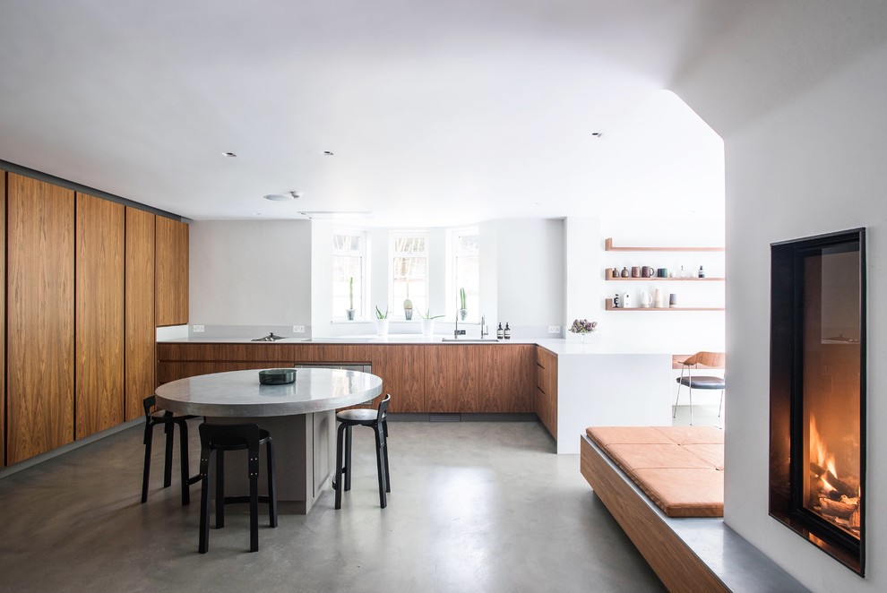 Example of a large trendy u-shaped concrete floor and gray floor open concept kitchen design in London with an undermount sink, flat-panel cabinets, quartzite countertops, white backsplash, stainless steel appliances, an island, white countertops and medium tone wood cabinets