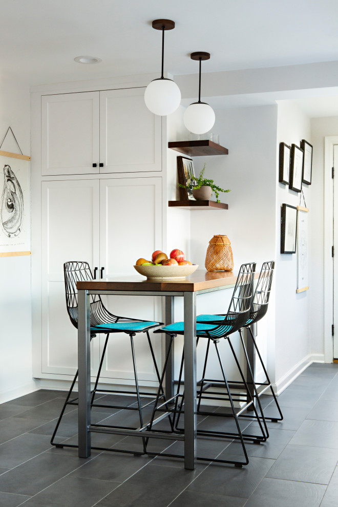 Exempel på ett mellanstort klassiskt grå grått kök, med en rustik diskho, skåp i shakerstil, vita skåp, bänkskiva i kvartsit, grönt stänkskydd, stänkskydd i keramik, rostfria vitvaror, skiffergolv, en halv köksö och svart golv