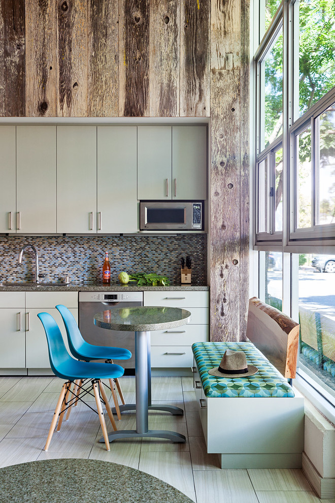 Medium sized industrial single-wall open plan kitchen in San Francisco with a submerged sink, flat-panel cabinets, green cabinets, engineered stone countertops, multi-coloured splashback, mosaic tiled splashback, stainless steel appliances, ceramic flooring, an island, grey floors and grey worktops.