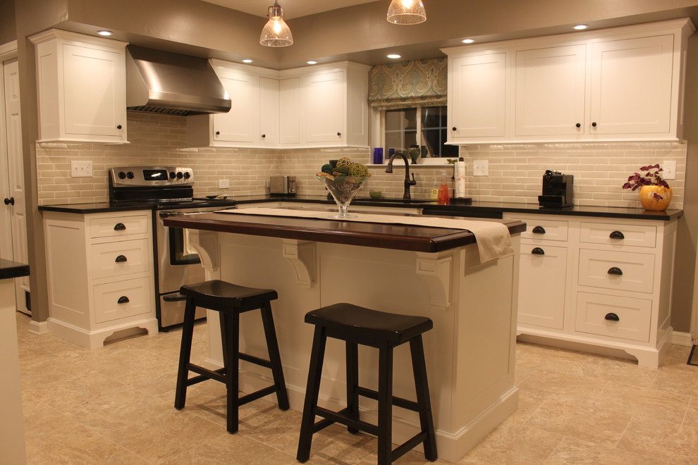 Bild på ett mellanstort funkis kök, med en undermonterad diskho, luckor med infälld panel, vita skåp, granitbänkskiva, stänkskydd i porslinskakel, rostfria vitvaror och en köksö