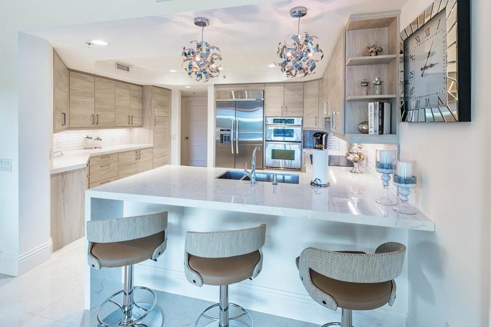 Mid-sized minimalist u-shaped porcelain tile and beige floor enclosed kitchen photo in Miami with a double-bowl sink, flat-panel cabinets, light wood cabinets, quartzite countertops, multicolored backsplash, mosaic tile backsplash, stainless steel appliances and a peninsula