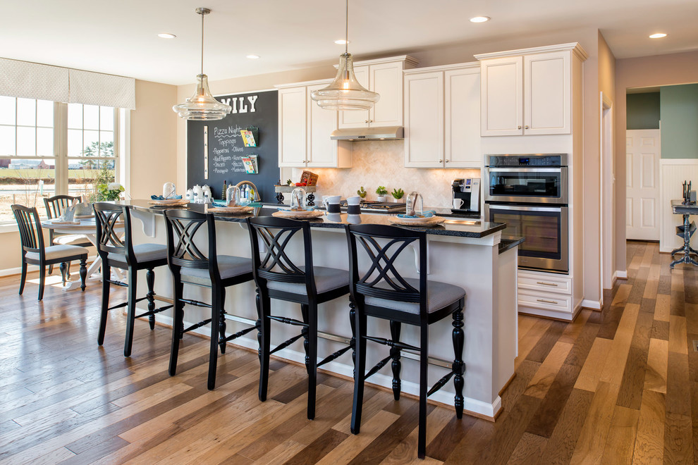 Einzeilige Landhaus Küche mit Schrankfronten im Shaker-Stil, Küchenrückwand in Beige, braunem Holzboden und Kücheninsel in Baltimore