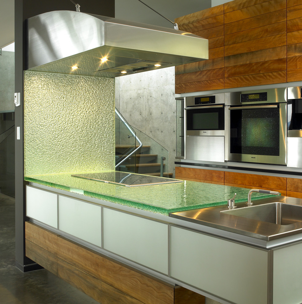 Ejemplo de cocina contemporánea con encimera de vidrio y encimeras verdes