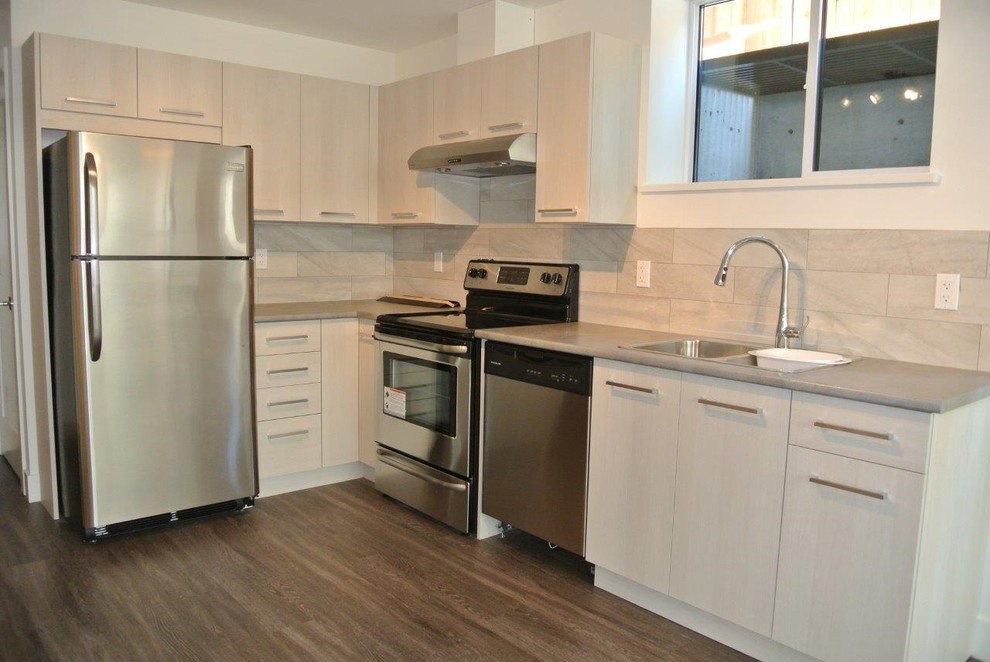 Immagine di una cucina minimal di medie dimensioni con ante lisce, ante bianche e top in quarzo composito