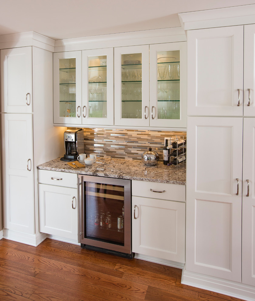 Exempel på ett stort klassiskt beige beige kök, med en undermonterad diskho, skåp i shakerstil, vita skåp, granitbänkskiva, flerfärgad stänkskydd, stänkskydd i stickkakel, vita vitvaror, mellanmörkt trägolv, en halv köksö och brunt golv