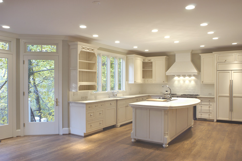 Mid-sized arts and crafts l-shaped medium tone wood floor eat-in kitchen photo in DC Metro with a double-bowl sink, louvered cabinets, white cabinets, granite countertops, white backsplash, subway tile backsplash, stainless steel appliances and an island