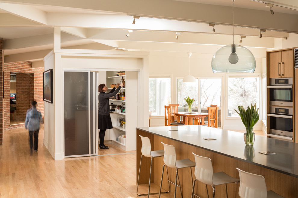 1950s light wood floor kitchen photo in Denver with flat-panel cabinets, light wood cabinets, stainless steel appliances and an island