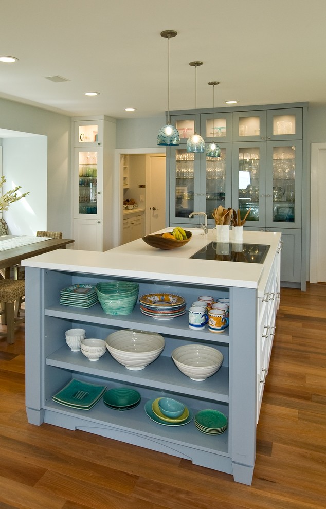 Cette image montre une arrière-cuisine encastrable ethnique avec un placard à porte shaker, des portes de placard bleues, un plan de travail en surface solide et îlot.