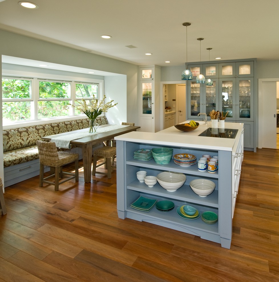 ハワイにあるトロピカルスタイルのおしゃれなキッチン (シェーカースタイル扉のキャビネット、青いキャビネット、人工大理石カウンター、パネルと同色の調理設備) の写真