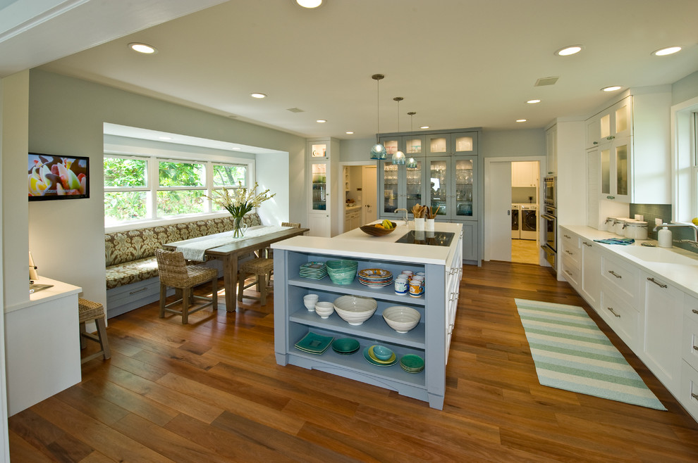 Island style kitchen pantry photo in Hawaii with an integrated sink, shaker cabinets, white cabinets, solid surface countertops, blue backsplash, glass tile backsplash, paneled appliances and an island