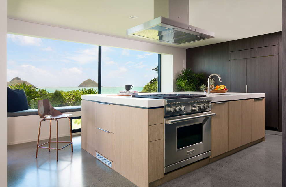 Foto di una cucina contemporanea con lavello sottopiano, ante lisce, ante in legno chiaro, pavimento in cemento, pavimento grigio e top bianco
